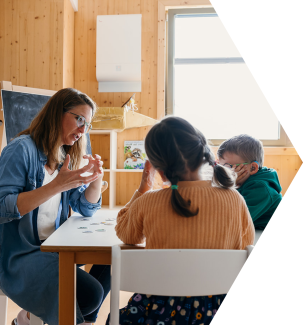 Eine Mitarbeiterin bei der Arbeit mit einem Mädchen und einem Jungen